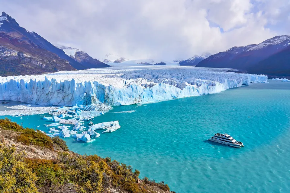 Glaciar Perito Moreno sobre el Lago Argentino, con un barco navegando entre los témpanos