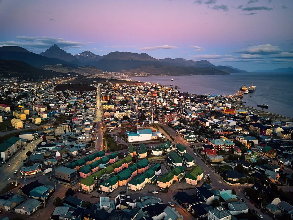 Vista aérea de Ushuaia al atardecer, con el Canal Beagle y las montañas